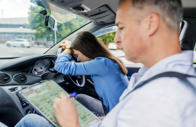 Driving test examiner filling in the report sheet after test candidate fails the test